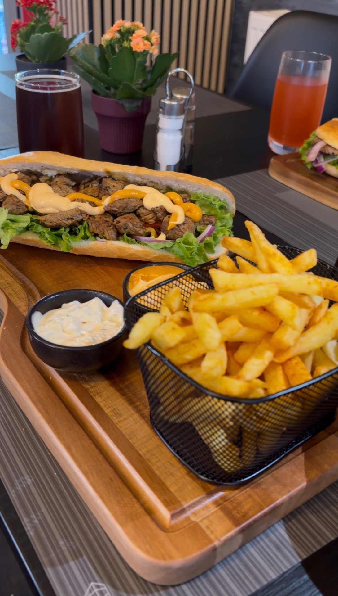 Warm broodje met stukjes beef, salade en friet
